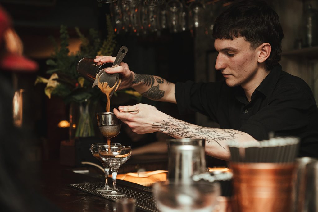 A member of bar staff at smokestack making cocktails